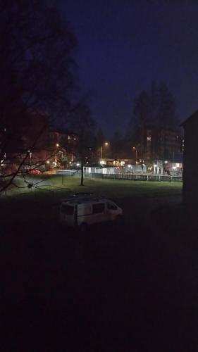 a park at night with a bench in the grass at M Apartments Tuularinkatu in Tampere