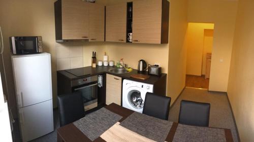 a small kitchen with a refrigerator and a table and chairs at Liivalaia Apartment in Tallinn