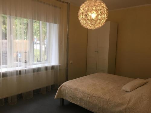 a bedroom with a bed and a chandelier at Liivalaia Apartment in Tallinn