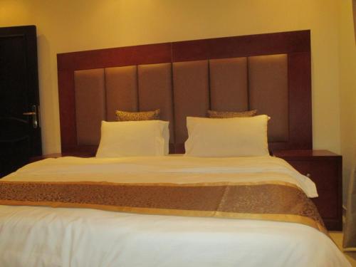 a bedroom with a large bed with white sheets and pillows at Leen Serviced Apartments in Jeddah