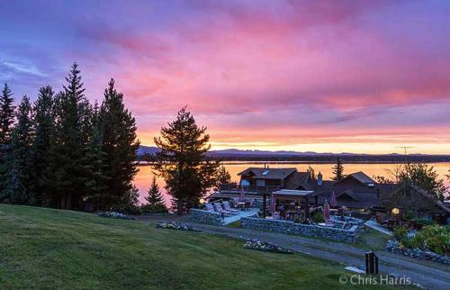una casa sulla riva di un lago al tramonto di Eagle's Nest Resort ad Anahim Lake