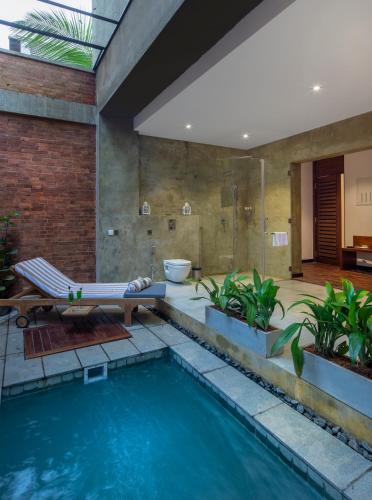 a bathroom with a swimming pool and a bath tub at Ayana Sea in Wadduwa