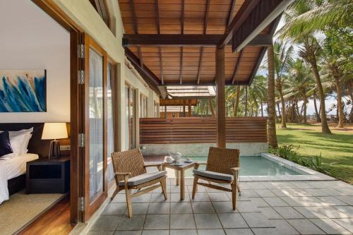 a patio with a table and chairs and a bed at Ayana Sea in Wadduwa