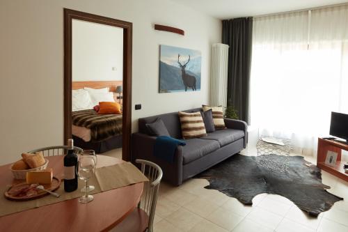 a living room with a couch and a bed at BASE CAMP alpine apartments in Breuil-Cervinia