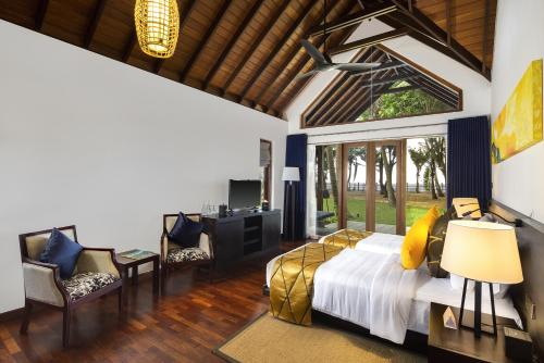 a bedroom with a bed and a desk and chairs at Ayana Sea in Wadduwa