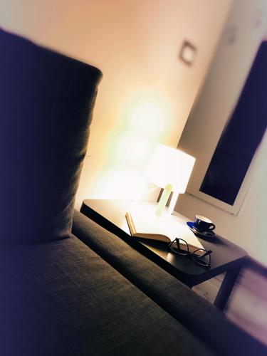 a bed with a lamp and a book on a table at Sweet Holiday Home in Bernalda