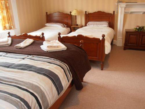 a bedroom with three beds with towels on them at Riversdale Farm B&B in Ballinamore
