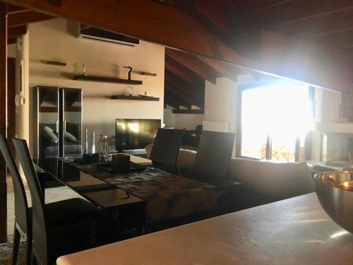 a dining room with a table with chairs and a window at The Loft in Chios