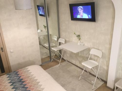 a room with a table and chairs and a tv at Дворик на Жуковского in Odesa