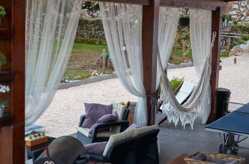 a living room with curtains and chairs and a patio at Quinta da Villa in Cascais