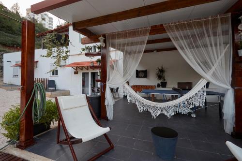 a patio with white curtains and a hammock at Quinta da Villa in Cascais
