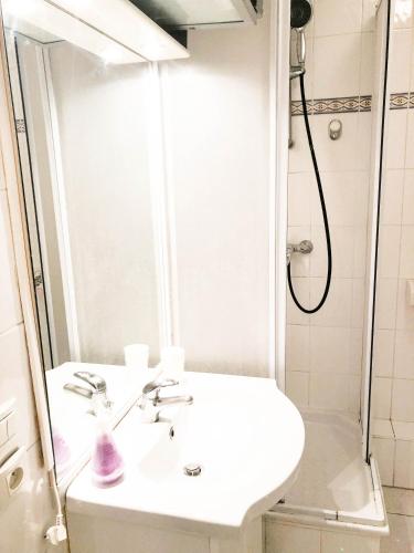 une salle de bain blanche avec un lavabo et une douche dans l'établissement Portobello residence, à Nice