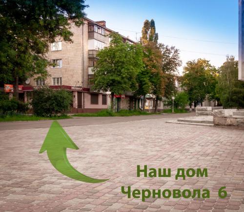 a green arrow on a street with a building at Luxury Loft в центре Полтавы in Poltava