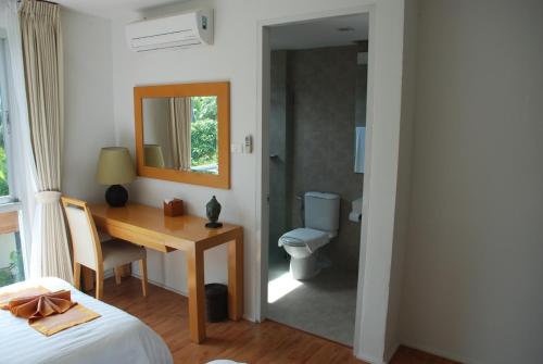 1 dormitorio con escritorio y baño con aseo en The Park Samui, en Choeng Mon Beach
