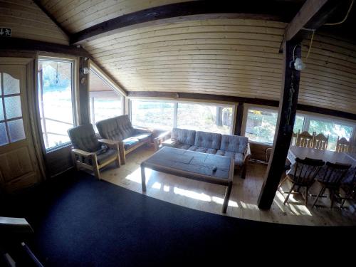 a living room with a couch and chairs in a house at Küljemäe puhkemaja in Otepää