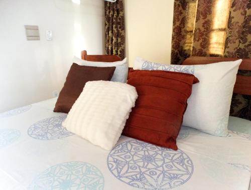 um monte de almofadas em cima de uma cama em Pousada Panceiro em Cabo Frio