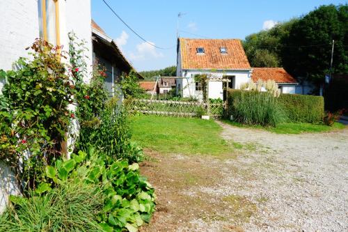 a garden with a house and a yard with plants at La Ferme De Tigny in Tigny-Noyelle