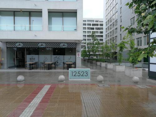a building with a sign in the middle of a courtyard at Excelente departamento en Las Condes in Santiago