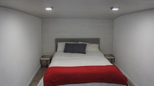 um pequeno quarto com uma cama com um cobertor vermelho em edificio Europa con vistas al veleta em Sierra Nevada