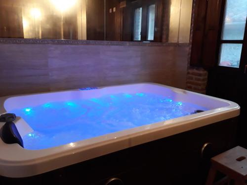 a large tub with blue water in a bathroom at La Currada in Taranes