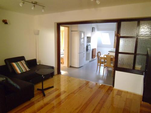 ミシュコルツにあるAulich Apartmanのリビングルーム(ソファ、テーブル付)、キッチンが備わります。