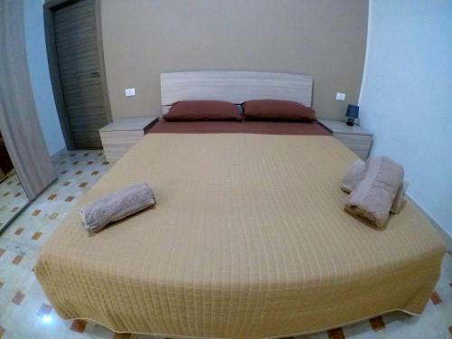 ein großes Bett in einem Schlafzimmer mit zwei Kissen darauf in der Unterkunft Welcome Home Apt. 2 in Pozzallo