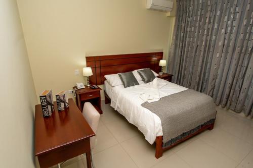 a bedroom with a bed and a desk and a bed sidx sidx sidx at LC Hoteles Piura in Piura