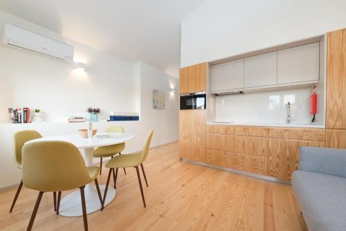 a kitchen and dining room with a table and chairs at Bom Jardim Apartments in Porto