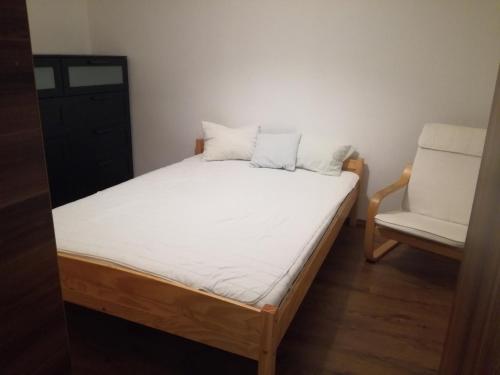 a bed and a chair in a room at Aulich Apartman in Miskolc