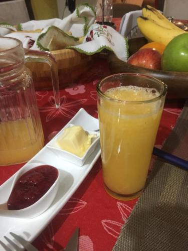 ein Glas Orangensaft neben einem Teller Obst in der Unterkunft Departamento Para Turistas in Lima