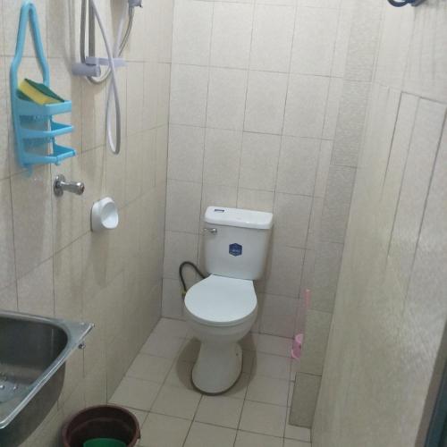 a small bathroom with a toilet and a sink at Angeles City Guesthouse in Angeles
