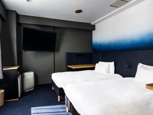 En eller flere senge i et værelse på Hotel New Shohei