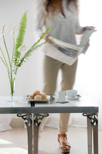 a woman is reading a newspaper on a table at Barceló Cairo Pyramids in Cairo