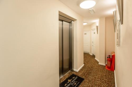 a room with a door open and a mirror on the wall at Prince Regent Hotel Excel London in London