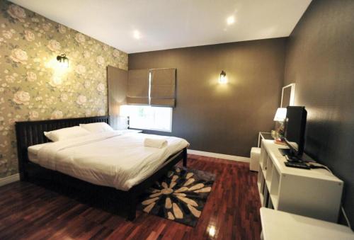 a bedroom with a bed and a television in it at Kenora Khaoyai Retreats - Private Pool Villa in Mu Si