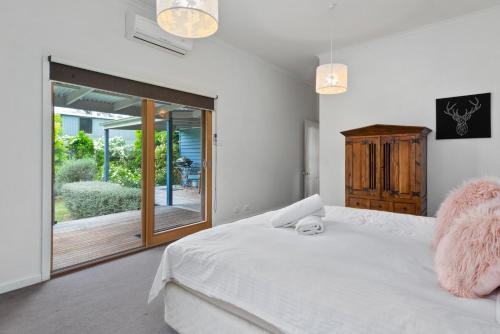 a bedroom with a white bed and a sliding glass door at Ultimate Ultimo in Mansfield