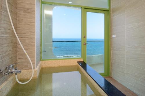 a bathroom with a view of the ocean and a window at 魚礁十五號民宿 FishHome 15 無電梯 NO ELEVATOR in Ruifang