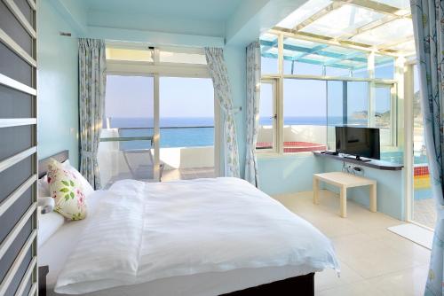 um quarto com uma cama e vista para o oceano em 魚礁十五號民宿 FishHome 15 無電梯 NO ELEVATOR em Ruifang