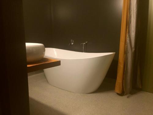 a white bath tub sitting in a bathroom at The Cliffs Seaside Lodge in Tuatapere