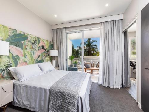- une chambre avec un lit et un balcon dans l'établissement Sleek, modern and comfortable on Hastings Street, à Noosa Heads