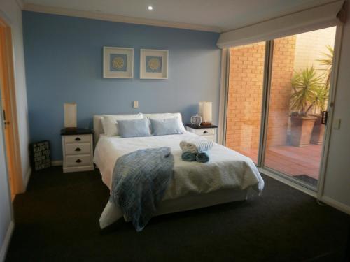 sypialnia z łóżkiem i dużym oknem w obiekcie Cowes Beachfront Retreat w mieście Cowes