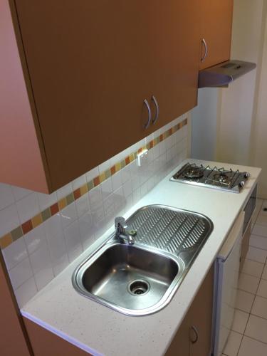 a kitchen counter with a sink and a stove at Flinders Street 238, CLEMENTS HOUSE at Federation Square, Melbourne, Australia in Melbourne