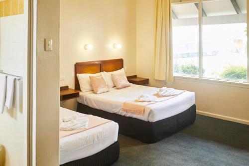a hotel room with two beds and a window at Town and Country Motel in Sydney