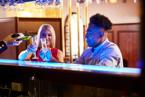 un homme et une femme buvant du vin au bar dans l'établissement Town and Country Motel, à Sydney