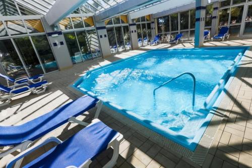 a swimming pool with lounge chairs and a swimming pool at ibis Sète Balaruc les Bains Bien-être et Spa in Balaruc-les-Bains
