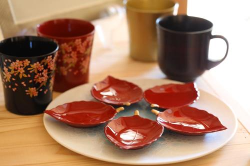 a plate with four chocolate covered cookies on a table with cups at Asahikan in Shiojiri
