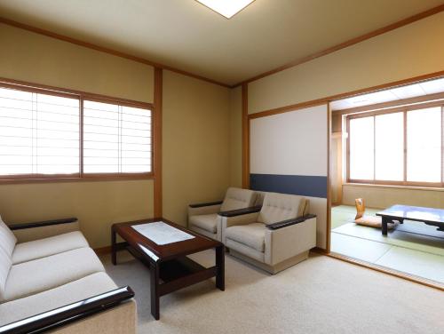 a living room with two chairs and a table at Asahikan in Shiojiri