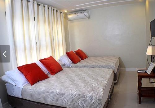 2 camas individuais num quarto com uma janela em The Guest House Laoag em Laoag