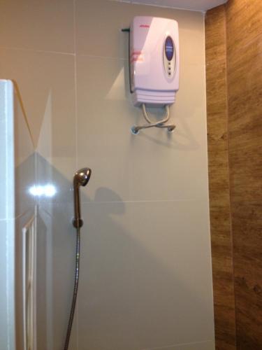 a shower in a bathroom with a pink hair dryer at Palm Sweet Resort in Chumphon