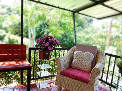 a chair sitting on a balcony with a potted plant at Baan JaoKorKluay บ้านเจ้ากอกล้วย in Chiang Rai
